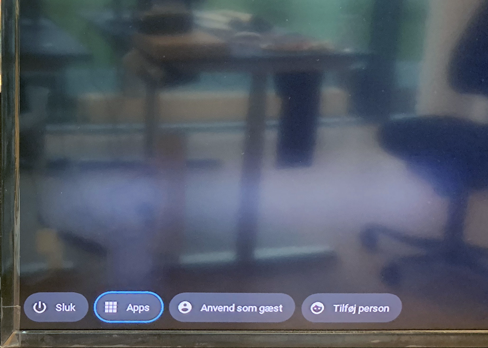 Device screen showing user options including 'Sluk' for power, 'Apps', 'Anvend som gæst' for guest use, and 'Tilføj person' to add a user, with a blurred background.
